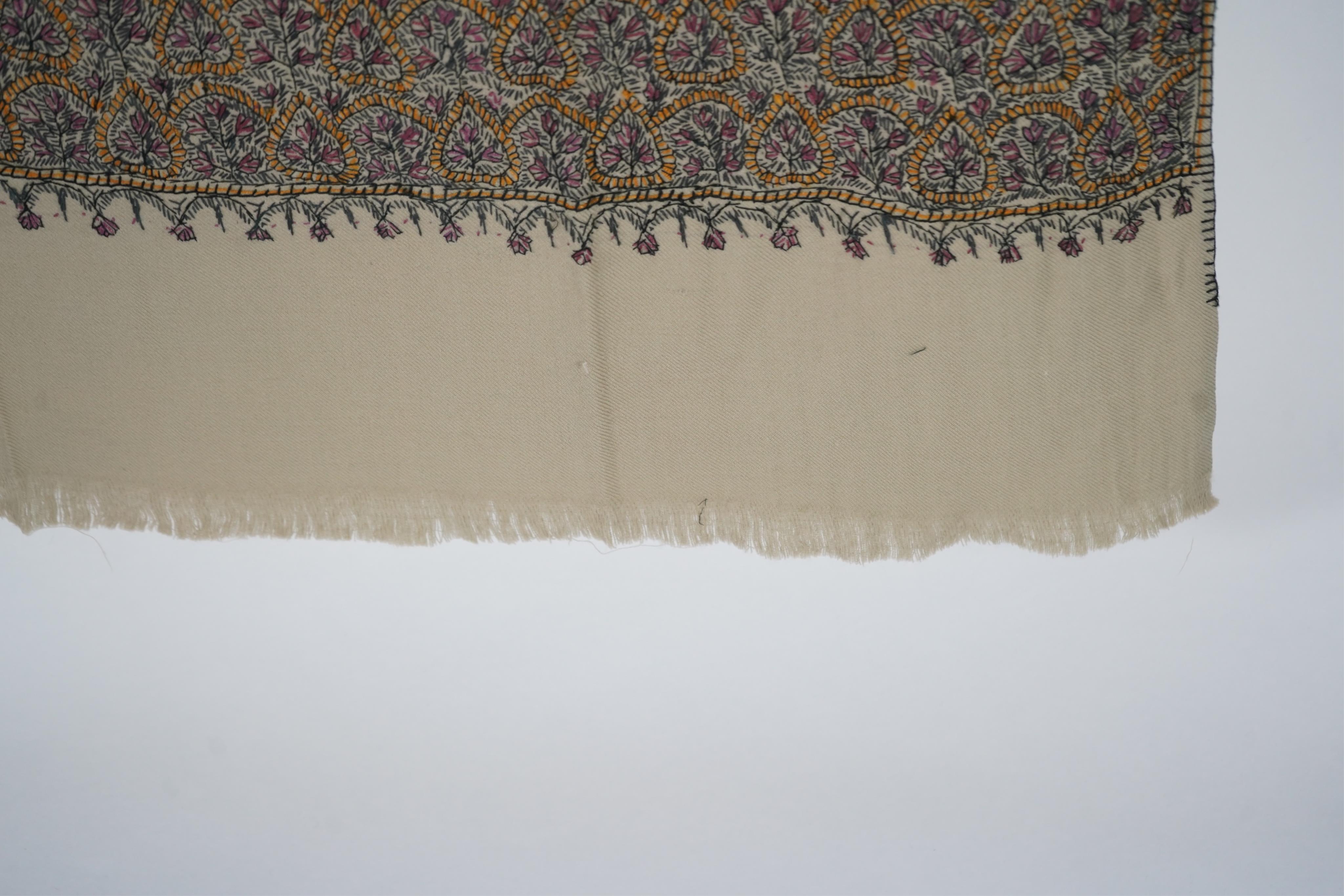 A 20th century ladies mushroom coloured Kashmiri black, yellow and grey silk embroidered stole, with two fine fringe edges, 190 cm long. Condition - a small moth hole near the embroidered border and one mark near one end